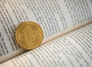 Bitcoin für Anfänger: Die wichtigsten Begriffe einfach erklärt Bitcoin-Begriffe: Eine Bitcoin-Münze liegt in einem Buch