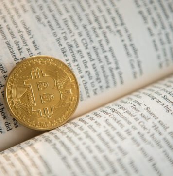 Bitcoin für Anfänger: Die wichtigsten Begriffe einfach erklärt Bitcoin-Begriffe: Eine Bitcoin-Münze liegt in einem Buch