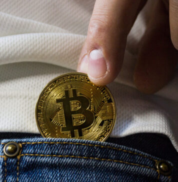 Bitcoins aufbewahren: So ist die Kryptowährung sicher Bitcoins aufbewahren: Jemand steckt einen Bitcoin in die Tasche