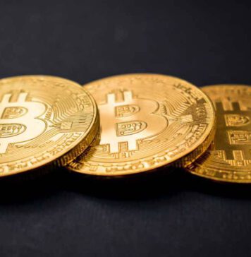 Was sind Bitcoins? Drei als Bitcoins geprägte, goldene Münzen